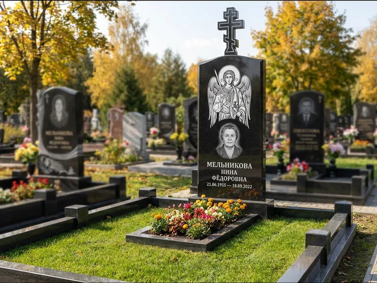 Памятник с гравировкой иконы: округлая стела-медальон с ликом — гравировка Богородицы «Семистрельная», луговые травы и полевые цветы за участком, работа «Гущин» в Самаре