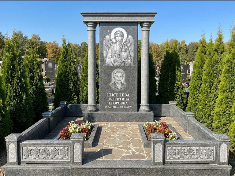 Памятник с гравировкой иконы: массивная стела с двускатным навершием-домиком — гравировка Николая Чудотворца, живая изгородь из туи, работа «Журавлёв» в Самаре