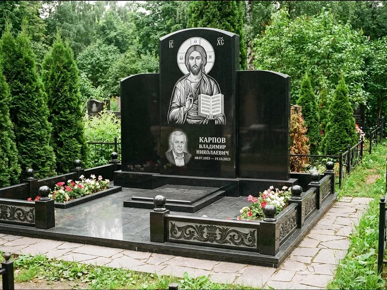 Памятник с гравировкой иконы: широкая панорамная стела с золочёным нимбом — гравировка образа Матроны Московской, цветник с белыми хризантемами, работа «Мельникова» в Самаре