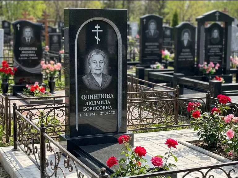 Памятник из чёрного гранита — скромная невысокая стела с крестом с терновым венцом, работа «Лаврентьева» в Самаре