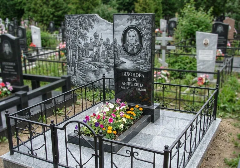 Памятник с гравировкой храма на фоне природы