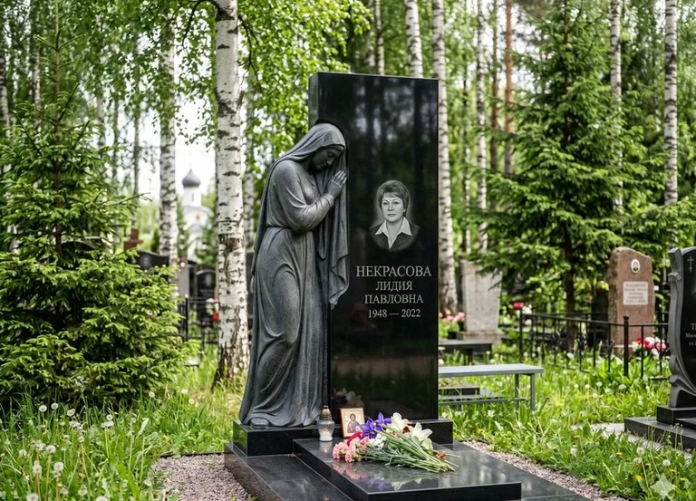 Гранитная фигура скорбящего мужчины у чёрной стелы в Самаре