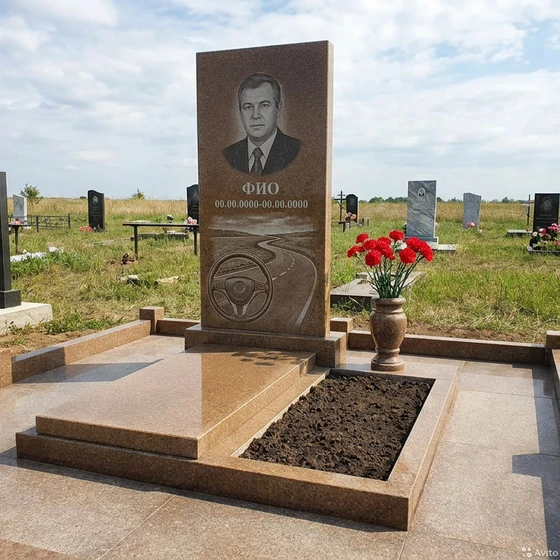 Гранитный памятник дальнобойщику с рулём и трассой